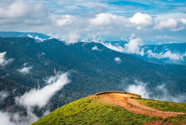 mountain with green grass and beautiful sky image is showing the amazing beauty and art of nature. This image is taken at karnataka india from hilltop.